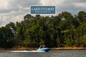 lake and coast real estate logo on picture of a boat on smith lake