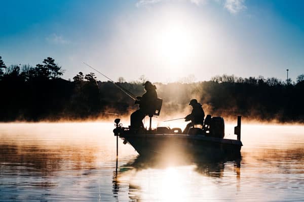 Fishing boat in the fog on a lake