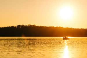 Fishing boat on lake at sunrise - Lake and Coast Realty